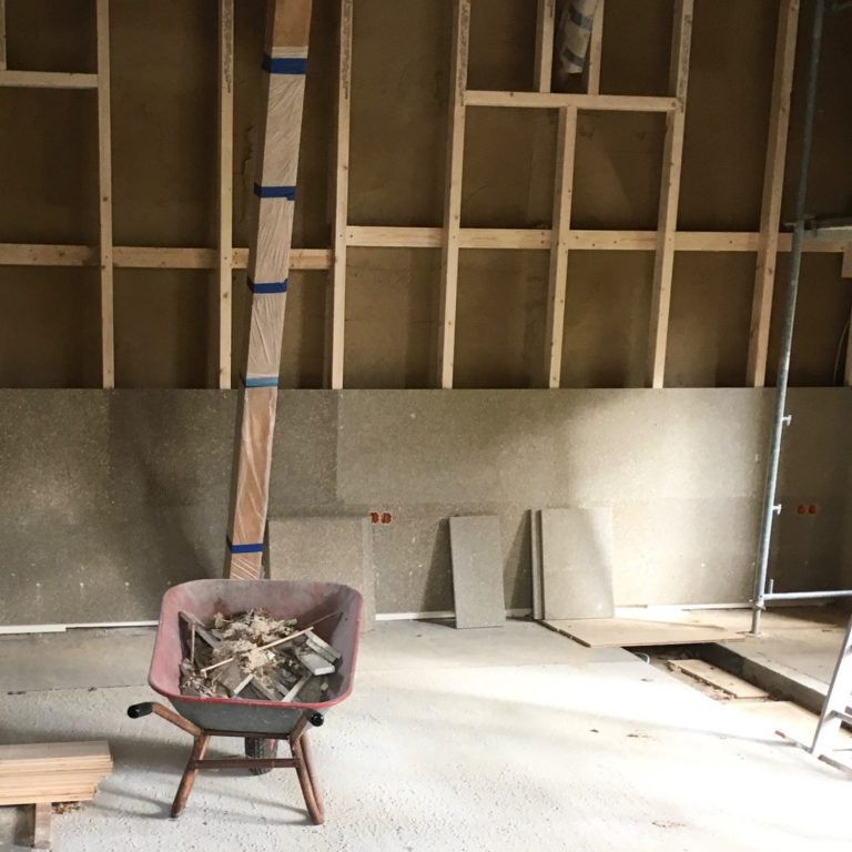 Eckdetail einer Fassade mit Ziegelsteinen und dekorativer Stuck-Verkleidung.