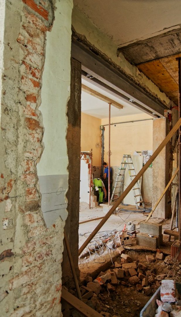 Blick auf eine Baugerüstkonstruktion an einer gedämmten Wand mit Werkzeugen und Materialien.