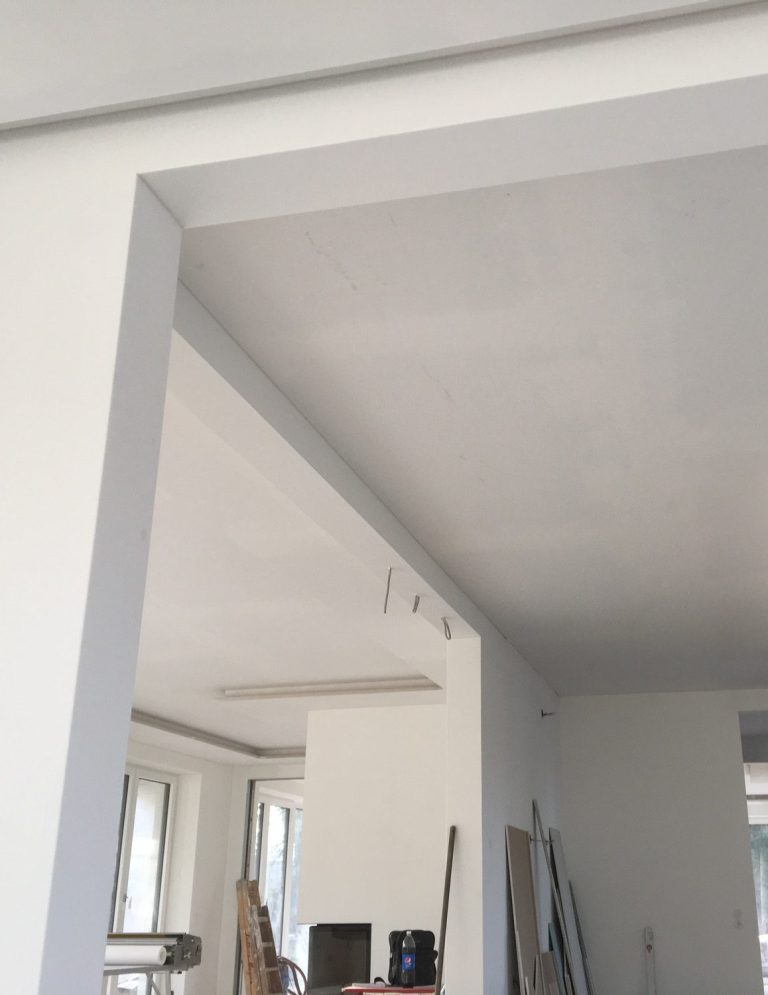 Dekorputz Helle Wand mit Schatten, die eine Ecke eines Raumes zeigt.