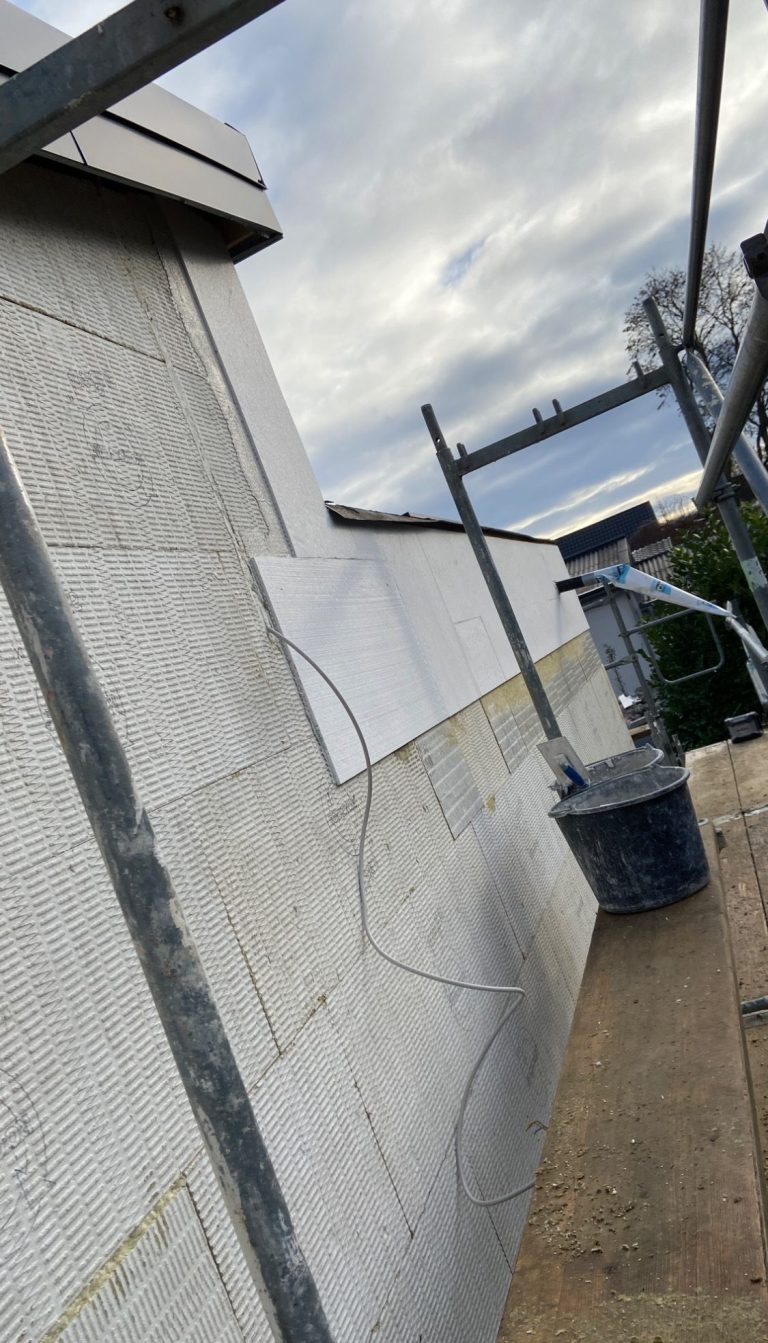 Holzrahmen und isolierte Decke in einem ungefertigten Raum mit einem Fenster.