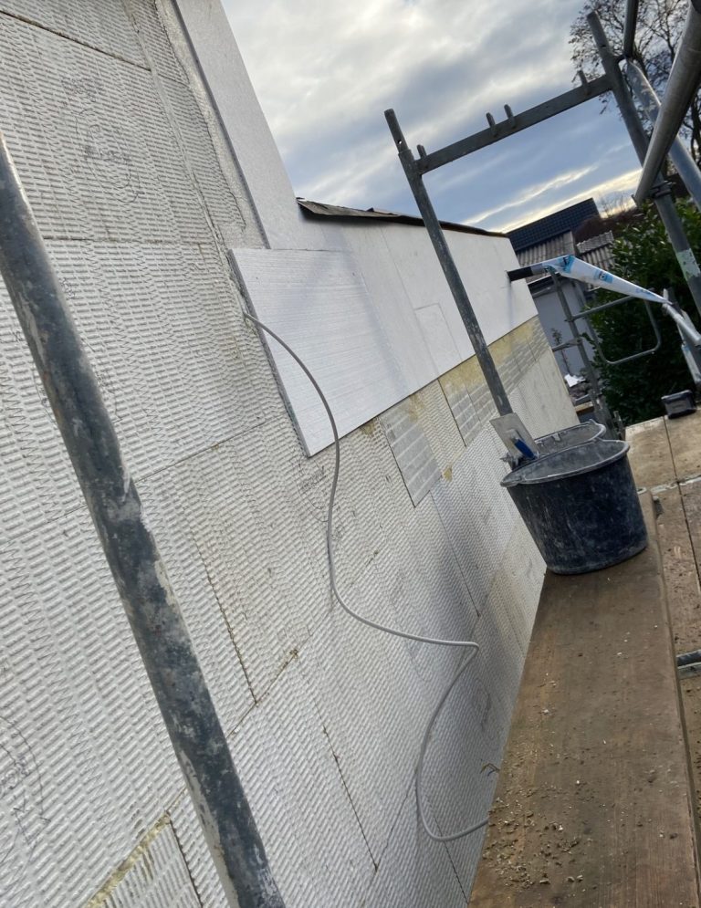 Helle Wand mit Schatten, die eine Ecke eines Raumes zeigt.