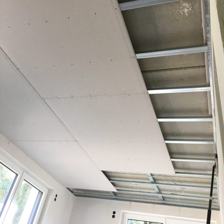 System Innendämmung Baustelle mit Schubkarre, Holzlatten und unvollendeten Wänden.
