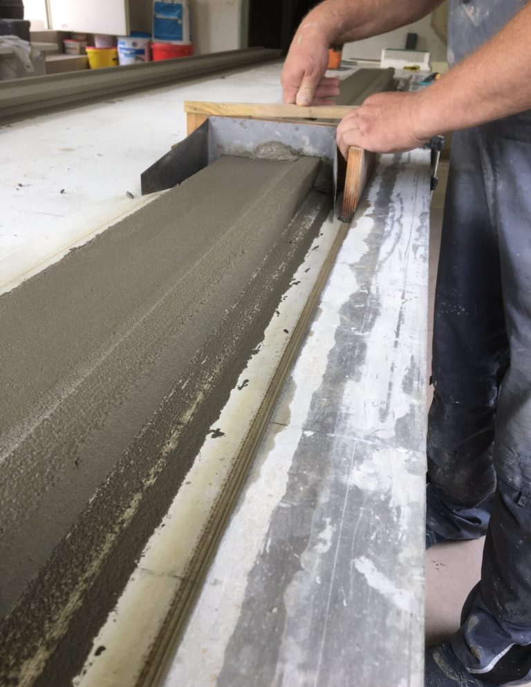 Helle Wand mit Schatten, die eine Ecke eines Raumes zeigt.